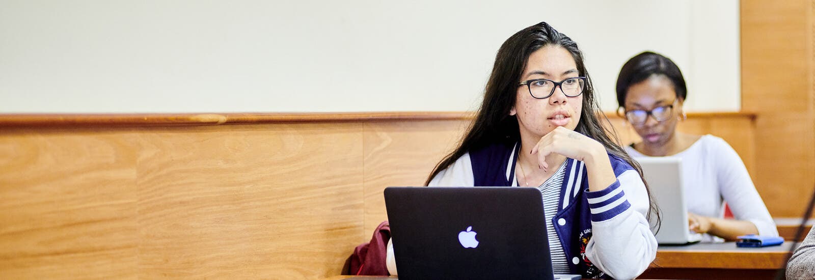 A student listening in class with a laptop