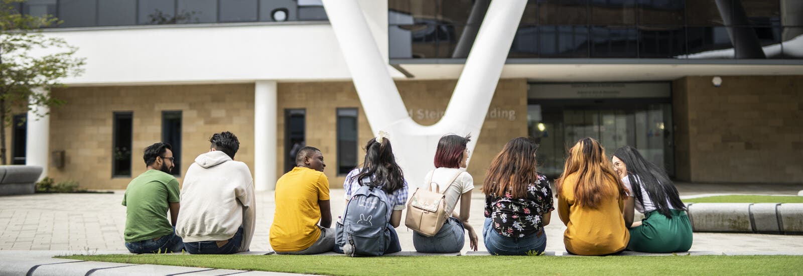 Students sitting outside campus building