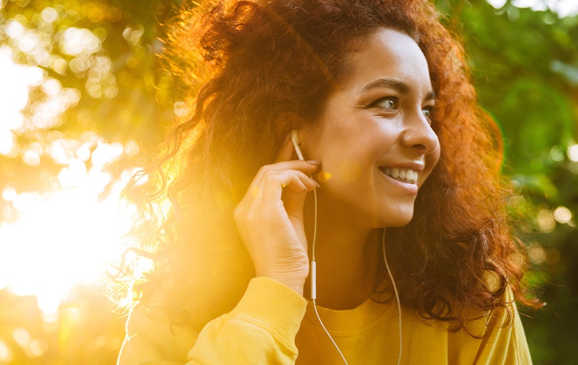 Woman listening to headphones in the sun
