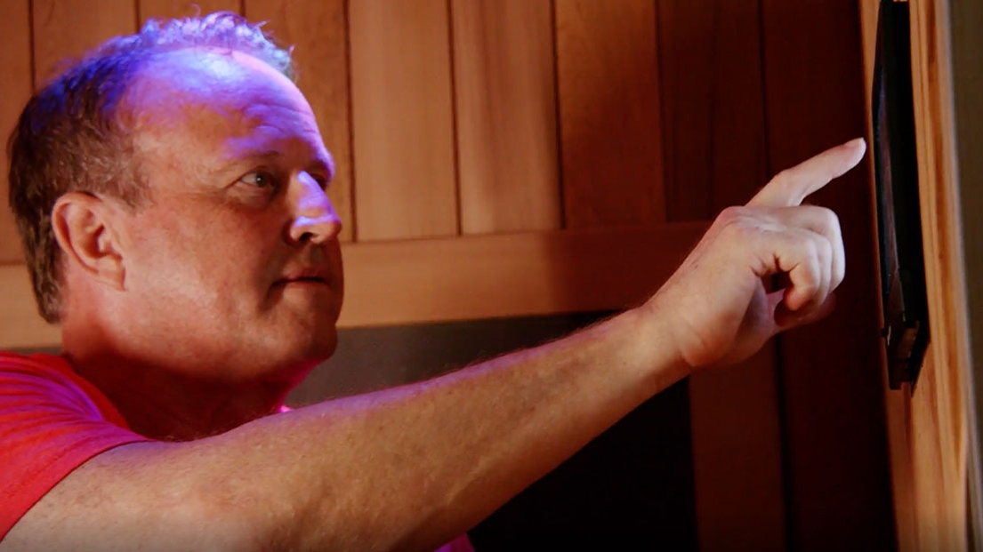 Darrell Mills operates the android tablet in a Sunlighten infrared sauna.