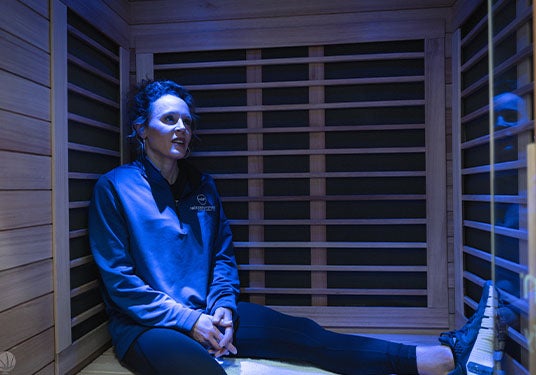 Jackie Stiles sitting in a Sunlighten sauna