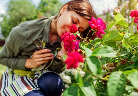 Woman smelling the flowers while gardening