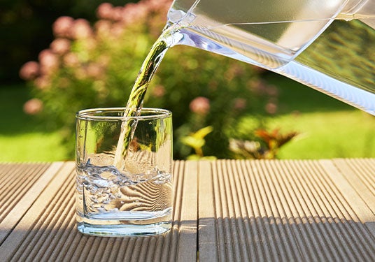 Pouring water from container into a glass