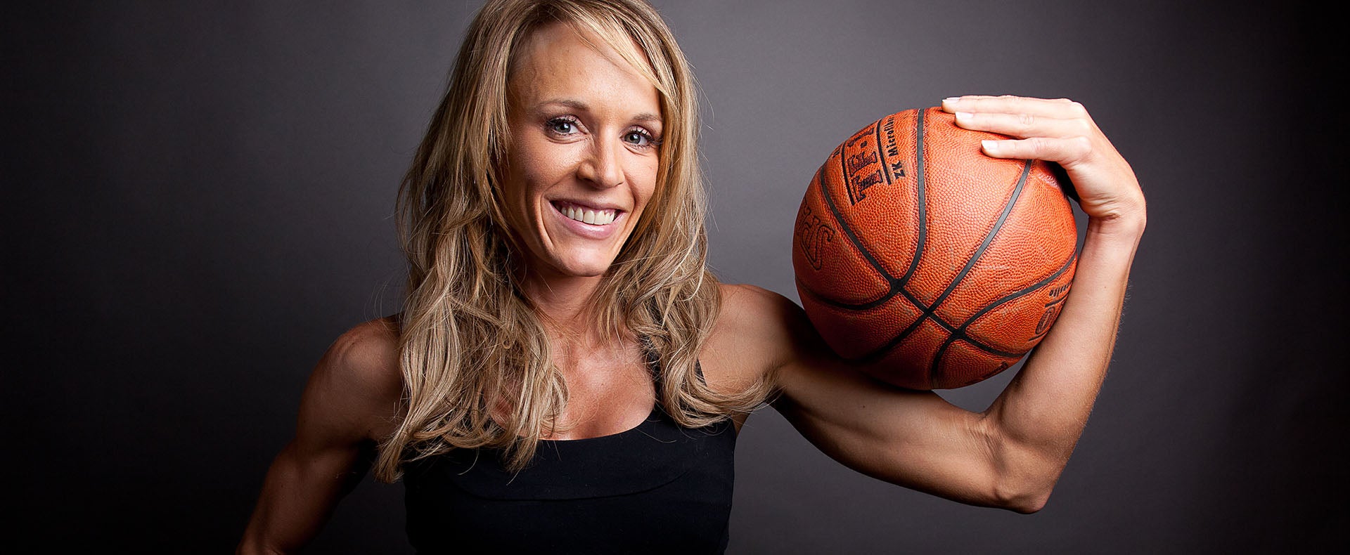 Jackie Stiles posing with a basketball