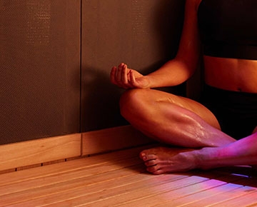 Woman meditating in a Sunlighten sauna