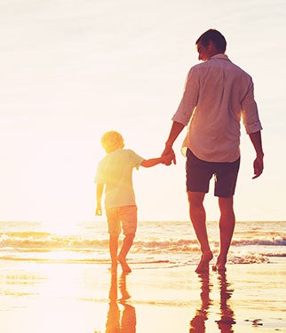 Man and son walking on the beach
