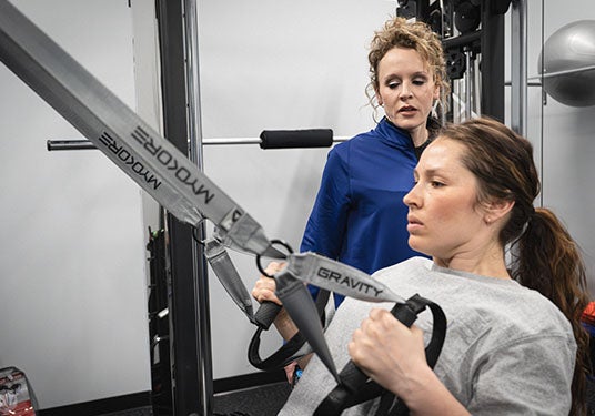 Jackie Stiles training a woman at her fitness center, NextGen Fitness
