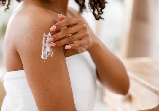 Woman applying lotion to arm