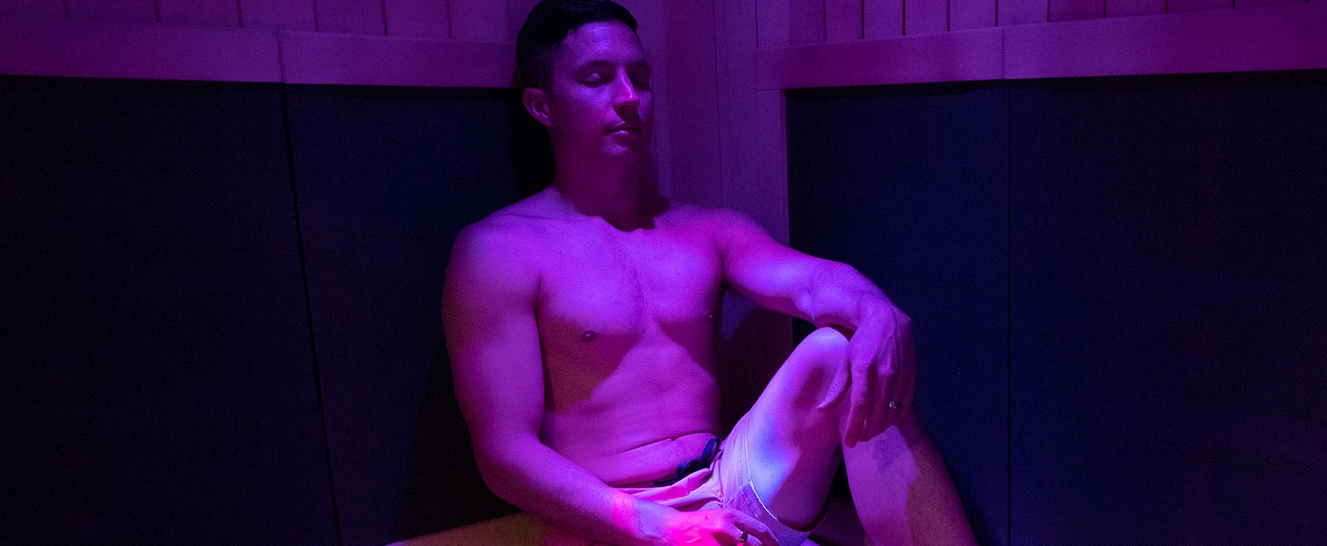 A man sits in an infrared sauna relaxing