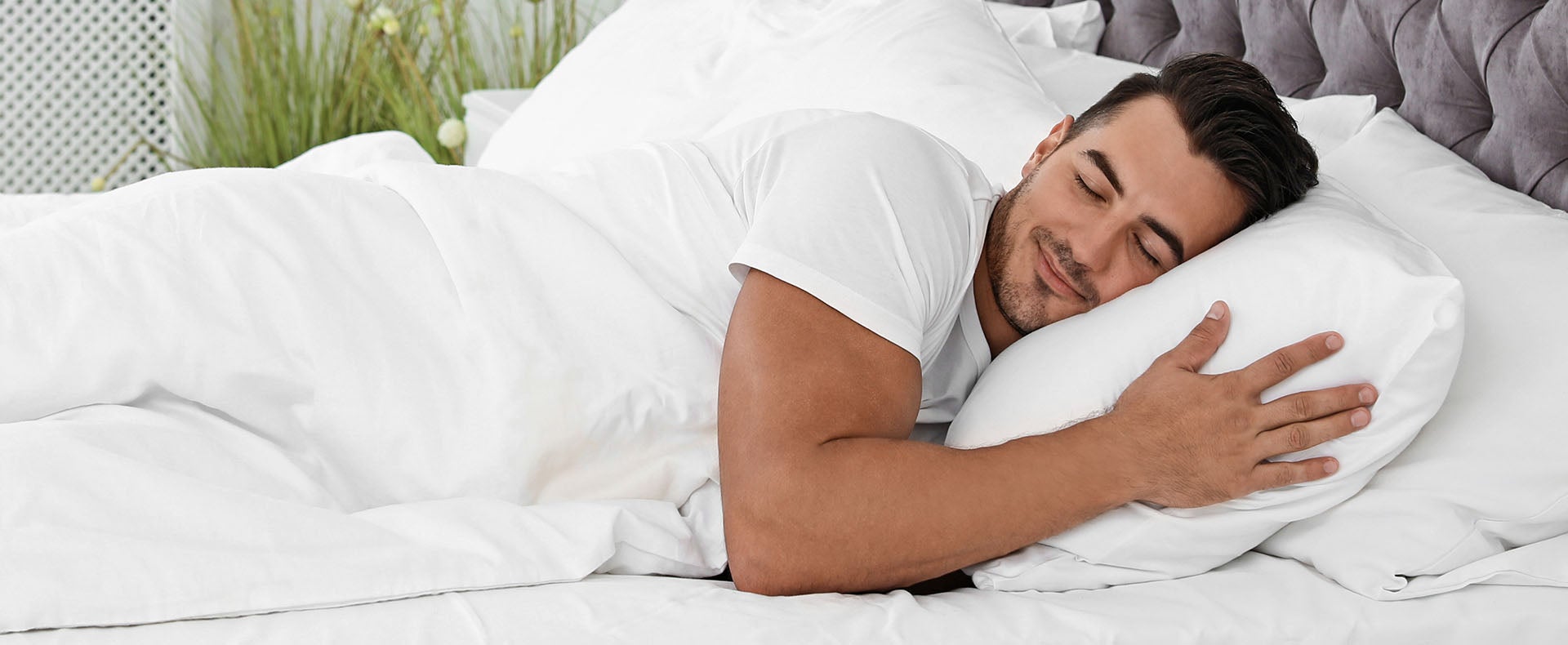 A man sleeps in bed after using a Sunlighten infrared sauna.