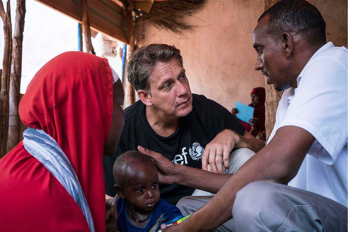 In Somalia, another country where poor rains and food shortages risk children’s lives, James listens to a nutrition officer as he screens a young boy for malnutrition