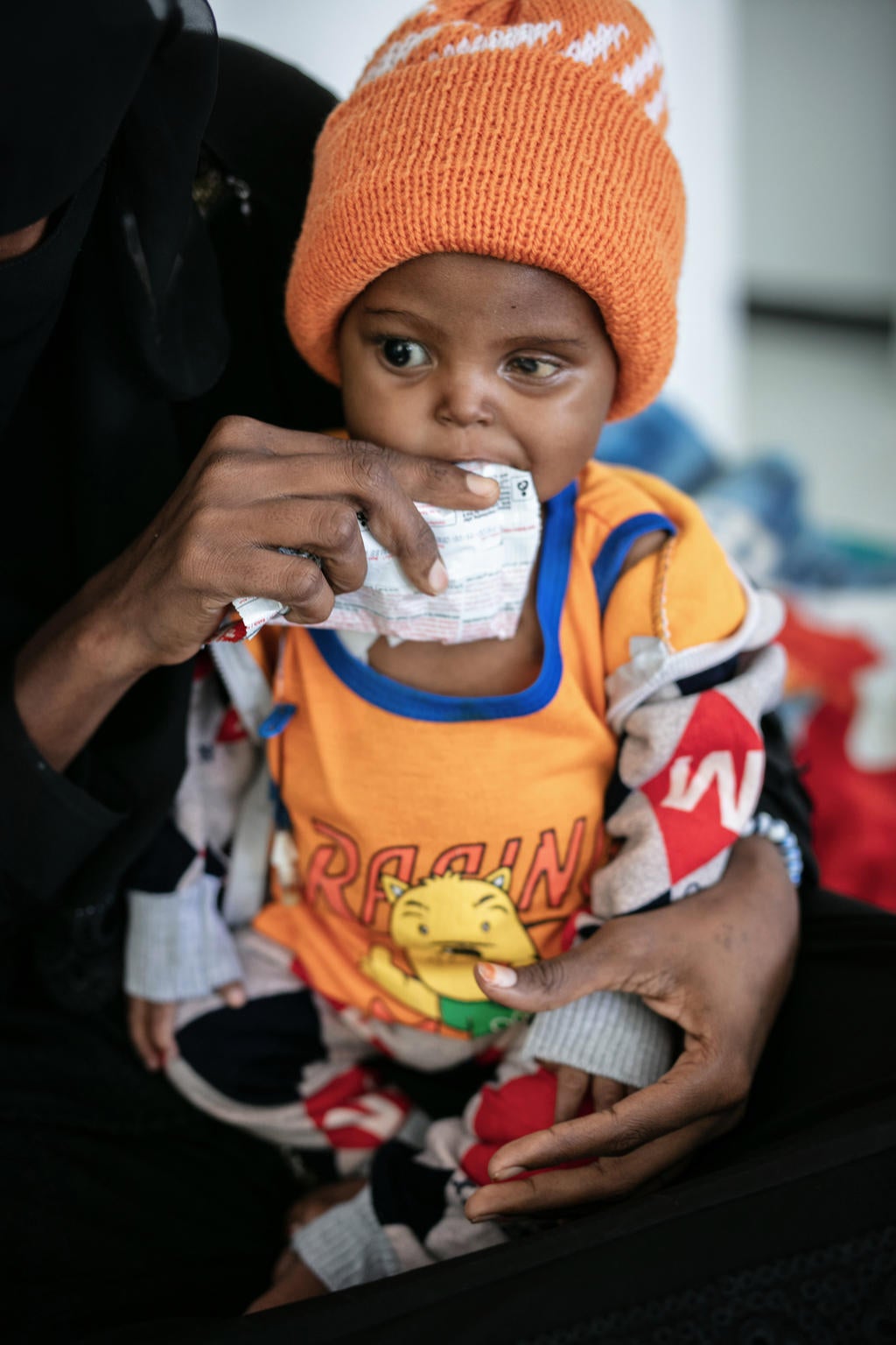 A baby is fed with sachet food.