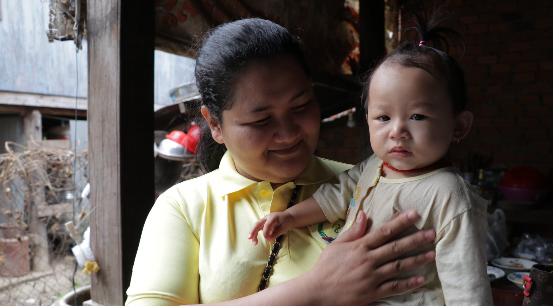 A lady smiling a baby in Cambodia