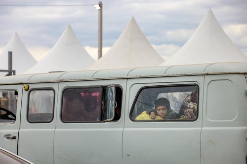 A boy inside a car fleeing his home