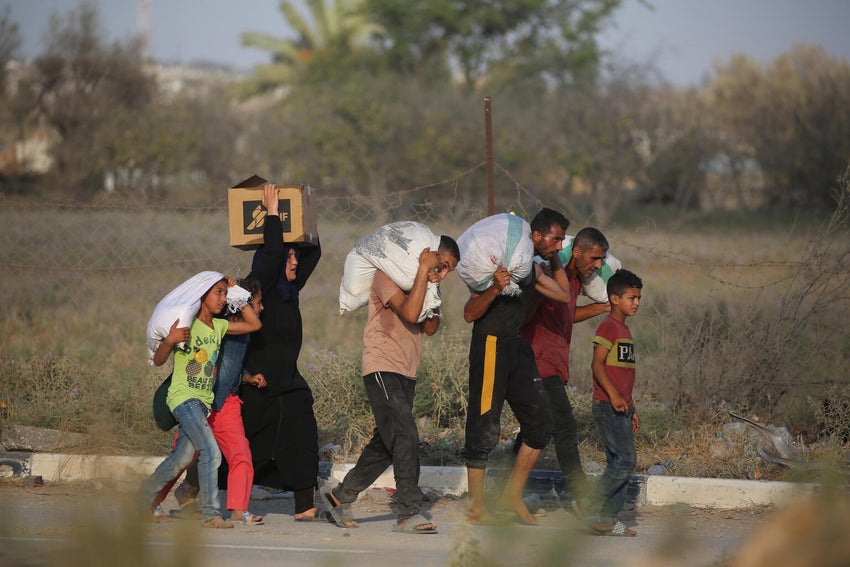 Families carrying humanitarian aid and supplies.