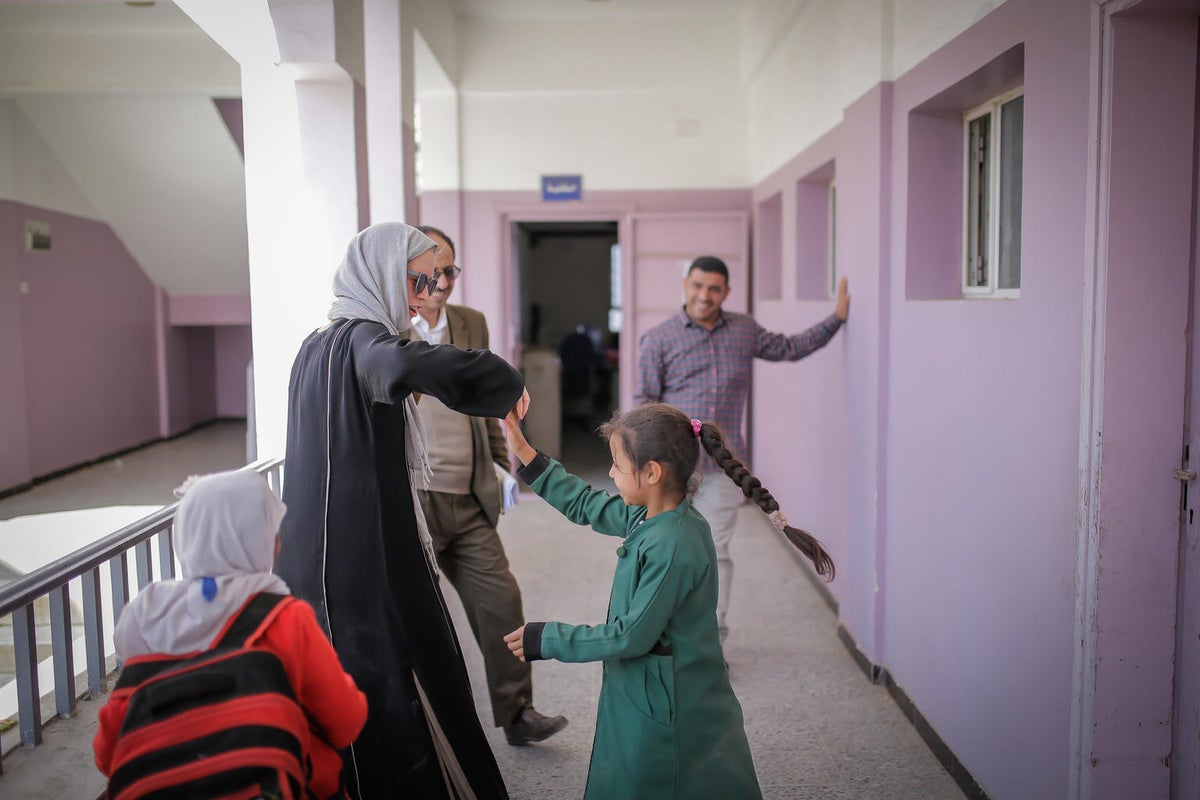 A woman is playing with a young girl