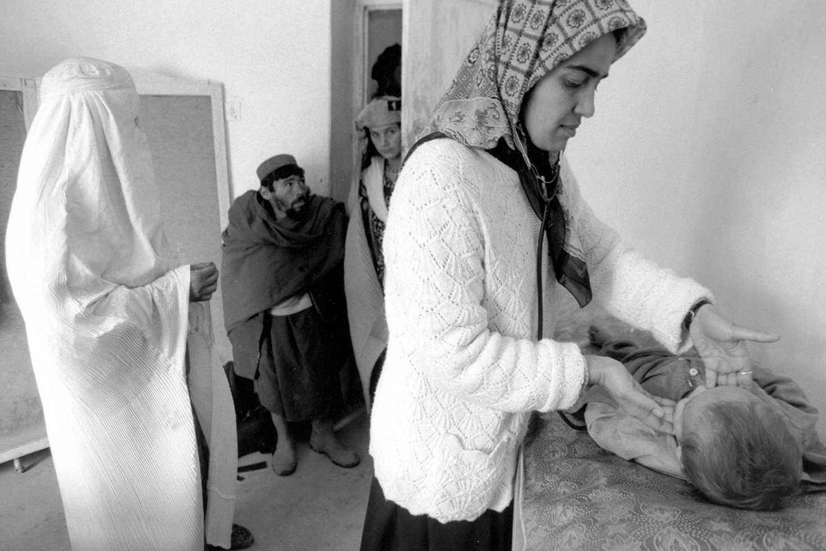 A female health worker examines a baby at the UNICEF-supported maternal and child health clinic in a hospital in Faizaba in 2000.
