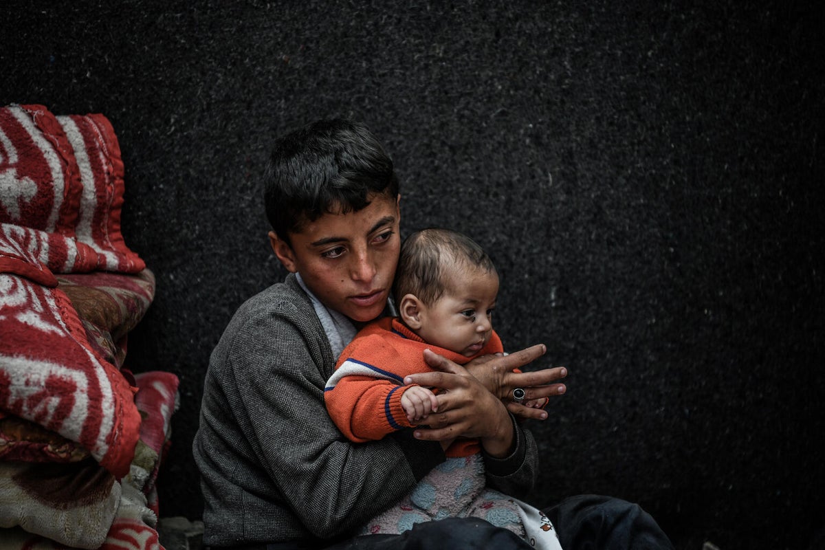 In Gaza, 11-year-old Mohammad holds his three-month-old sister.