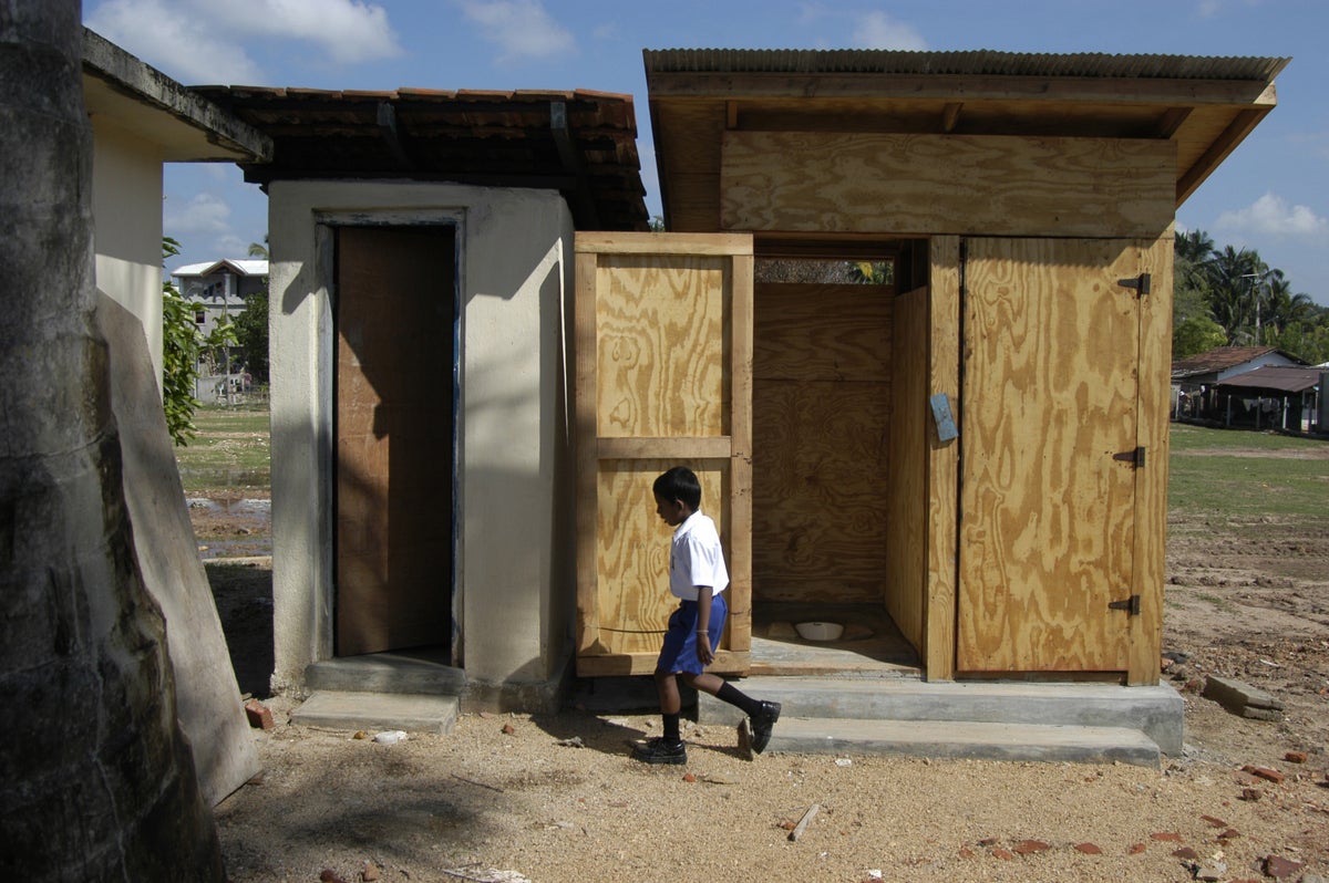 A boy walks past latrines, constructed with UNICEF assistance, at a school in Sri Lanka that was partially destroyed during the 2004 tsunami. 