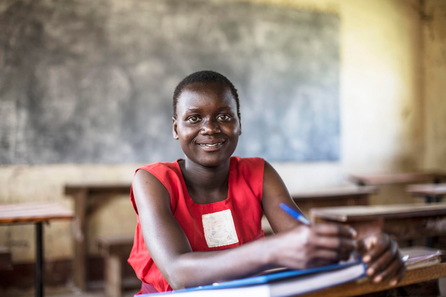 Faida Harriet sits in her classroom. She was rescued form a forced marriage and now back to school.