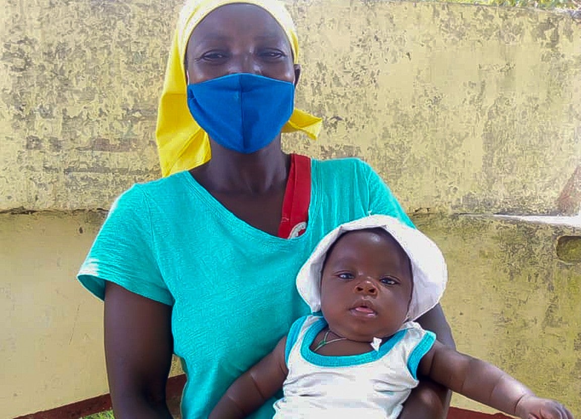 Mum Maria and her happy and healthy child in their home in rural Zimbabwe.