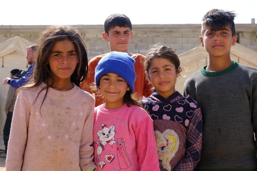 Syrian children standing outside their temporary shelters after the devastating earthquakes hit Turkiye and Syria in February 2023. 