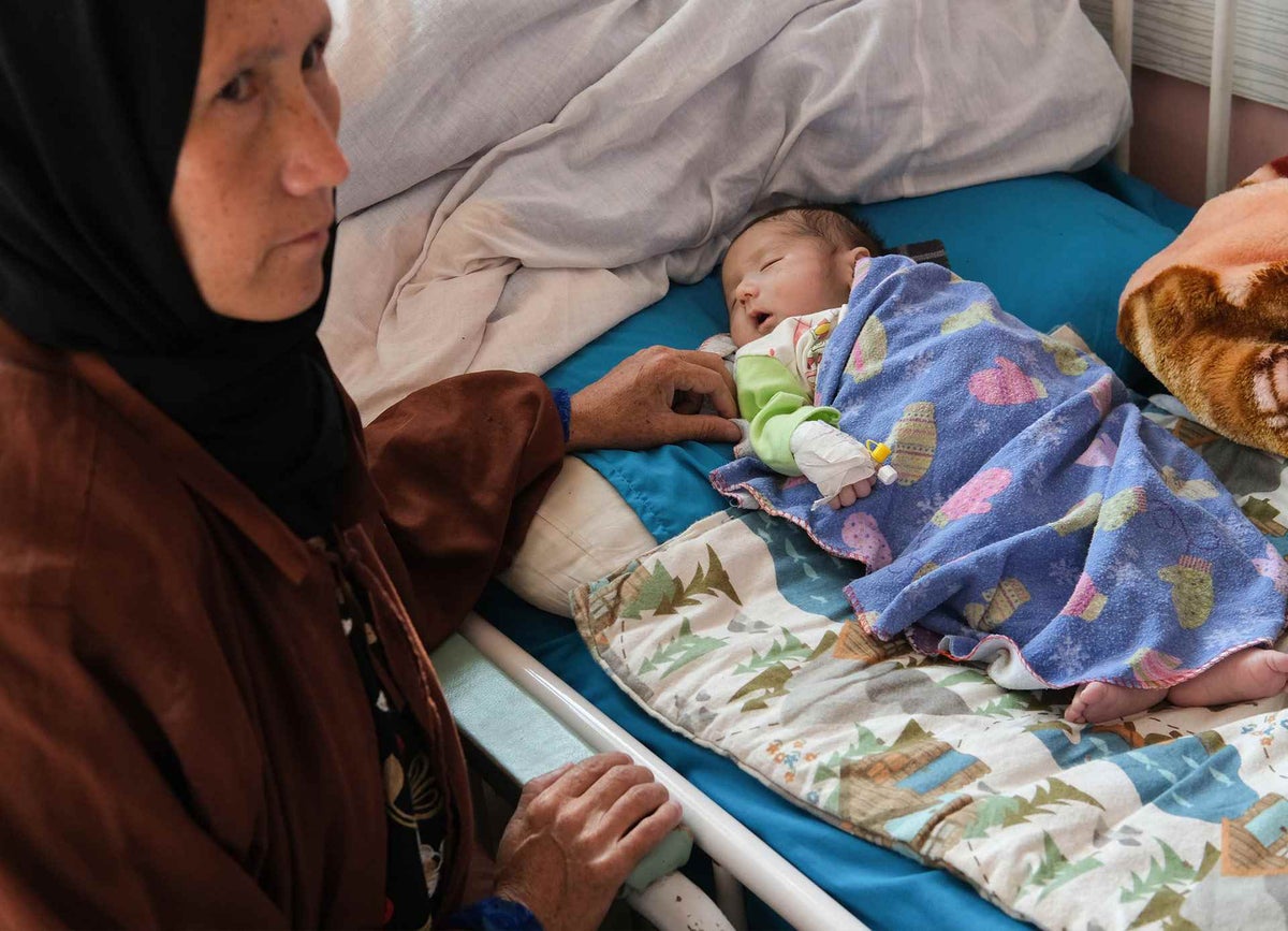 A mother sits beside her 36-day-old son at a hospital in Kabuln where he is being treated for severe acute malnutrition and oedma.