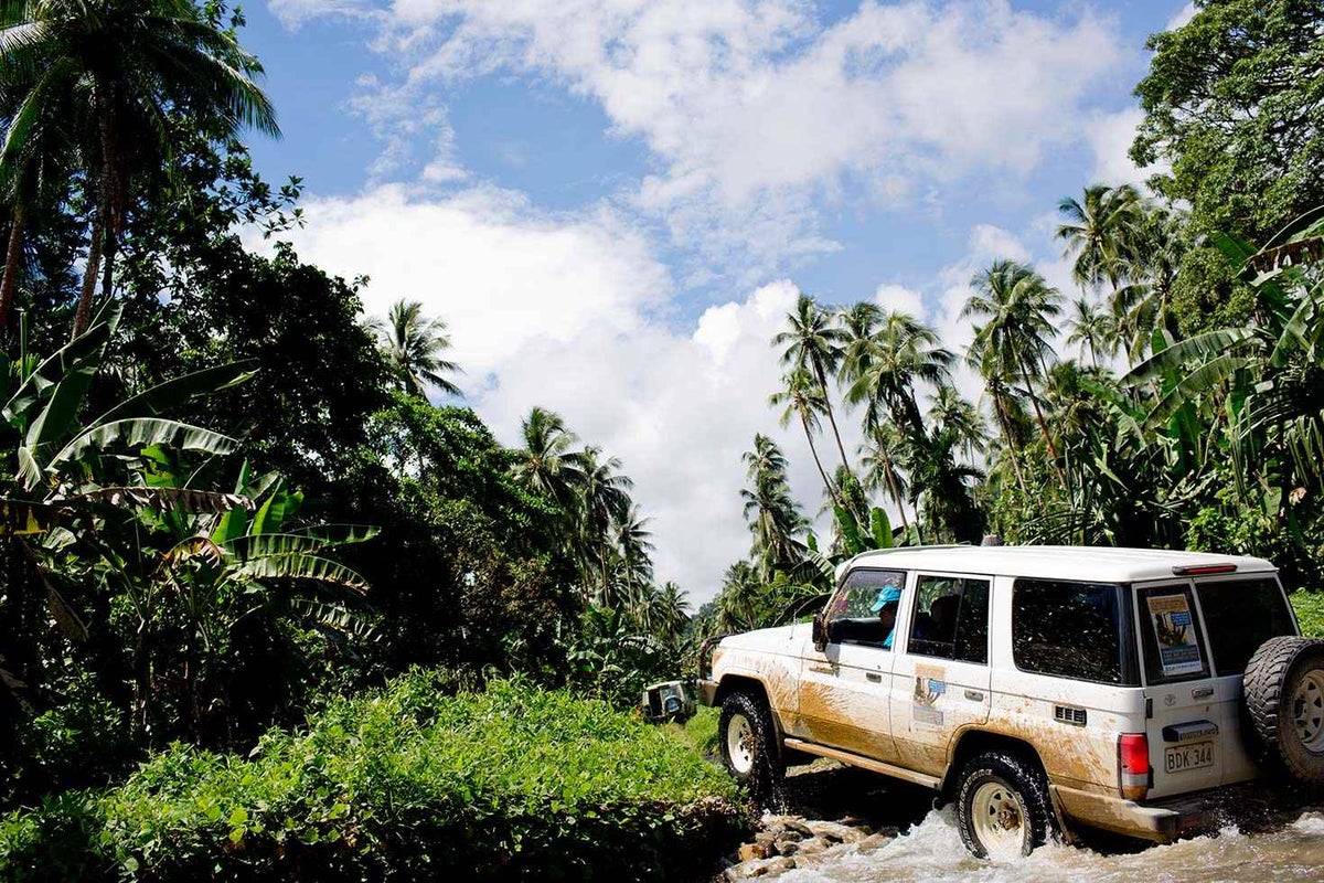 A UNICEF car drives through a river to reach a remote community in Kavieng in New Ireland Province, Papua New Guinea, to administer polio vaccines.