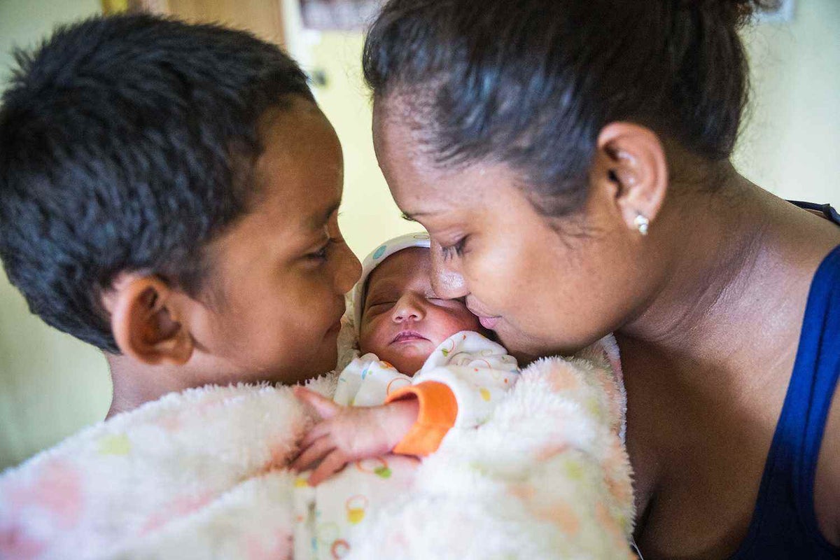 Avalon and her young son Caleb hold newborn baby Tina in Fiji in 2016