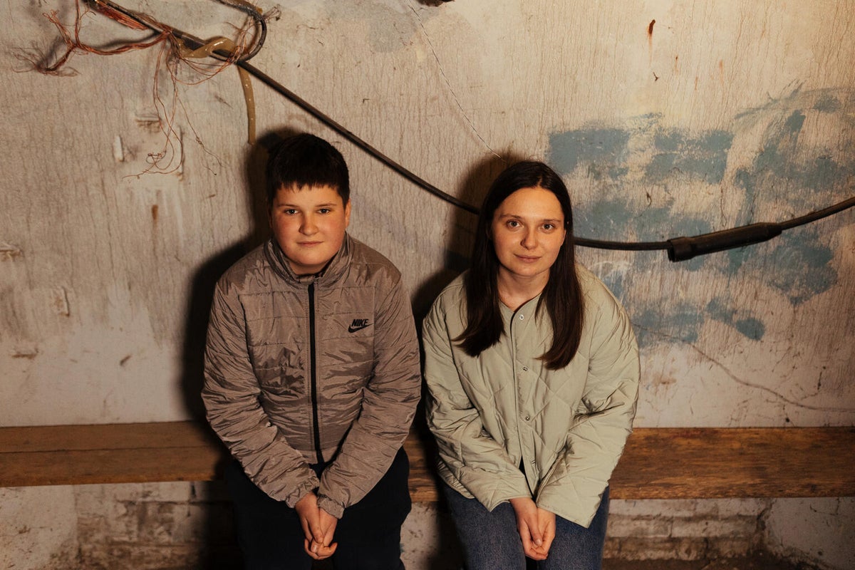 Brother and sister sit together in the basement in Ukraine