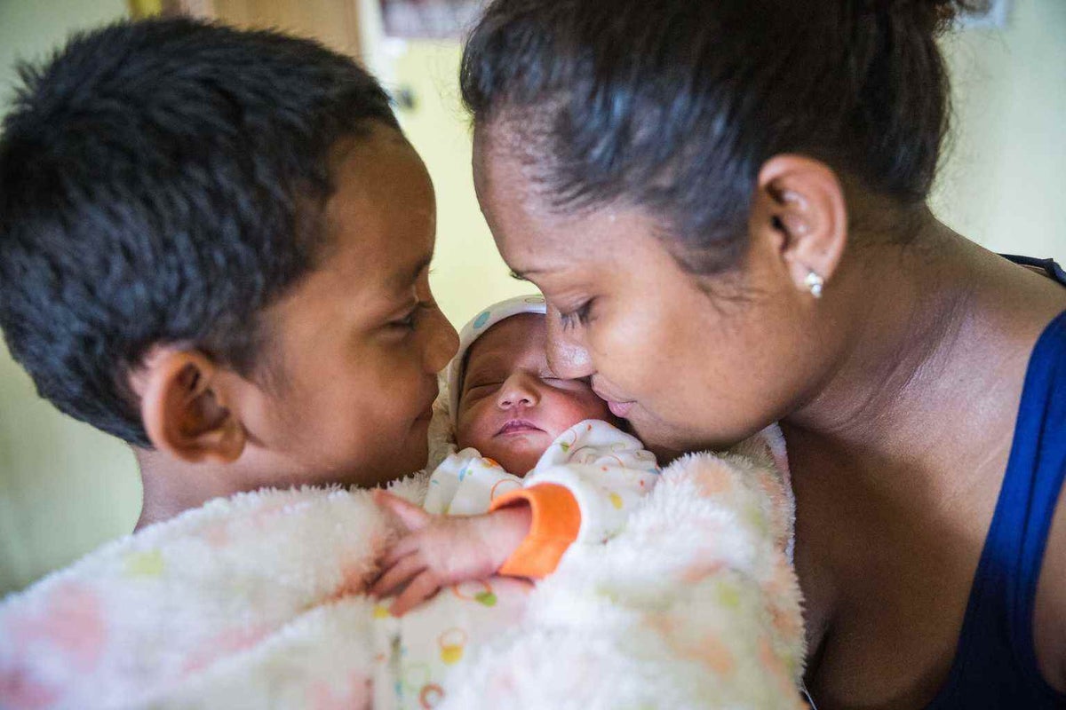 Avalon and her young son Caleb hold newborn baby Tina in Fiji in 2016. 