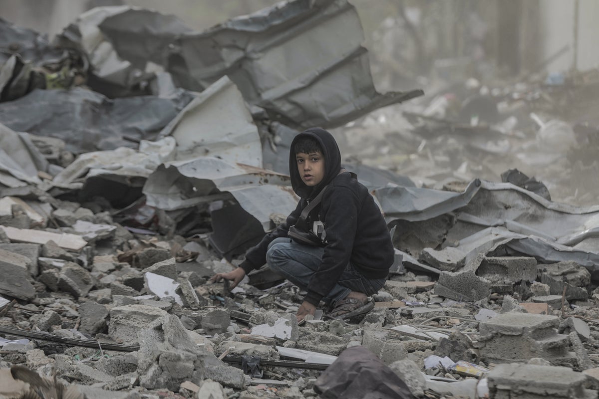 A 10-year-old boy searches through the rubble of his home in Gaza.
