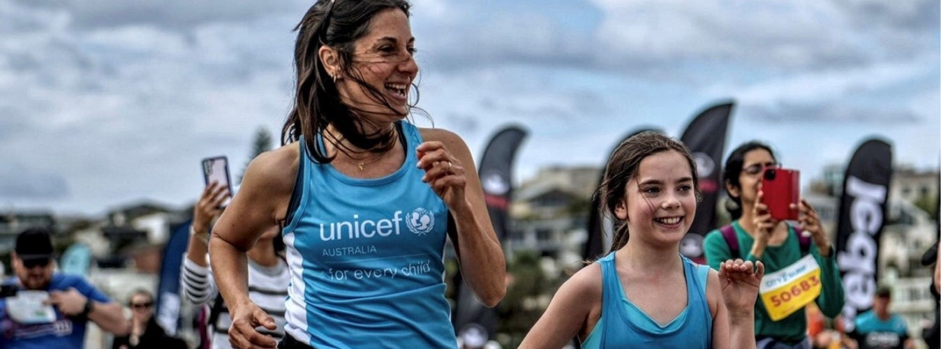 A mother and daughter taking part in a community running event. 