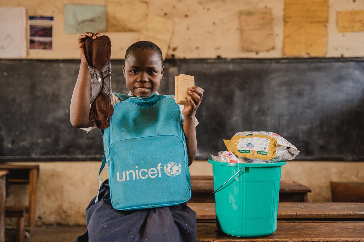 Aimerance, 13, holds a reusable sanitary pad and a bar of soap from her female hygiene kit in the Democratic Republic of the Congo.