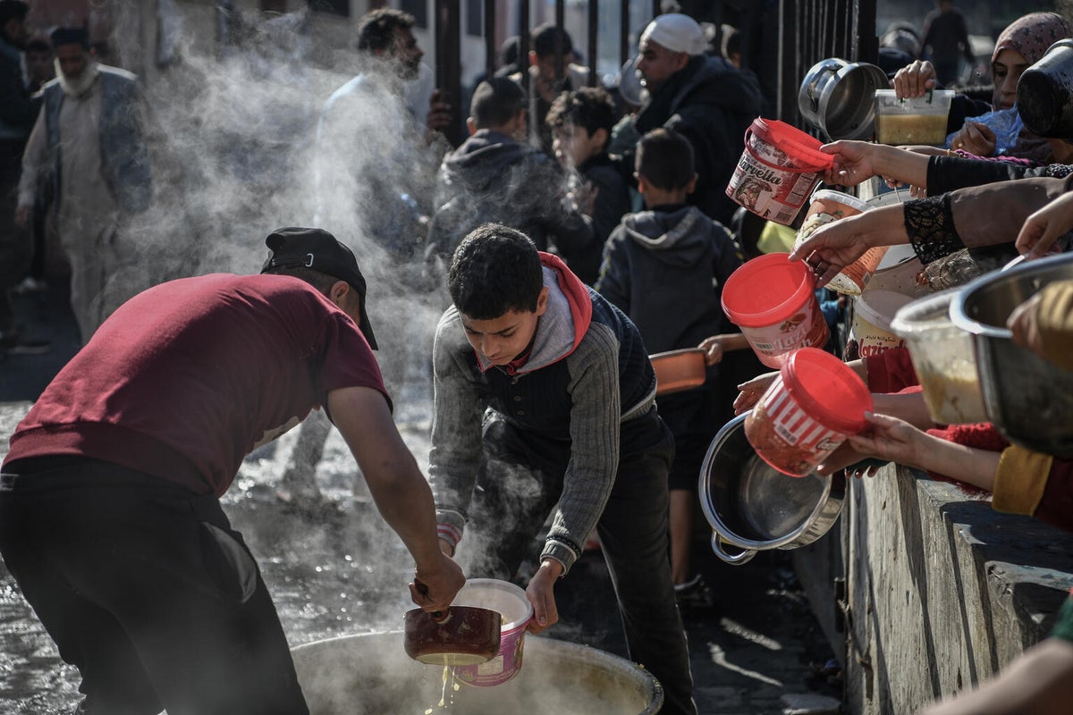 People wait in a long line to receive a small amount of food in the Gaza Strip, where more than half a million people, are facing catastrophic levels of food shortages. 