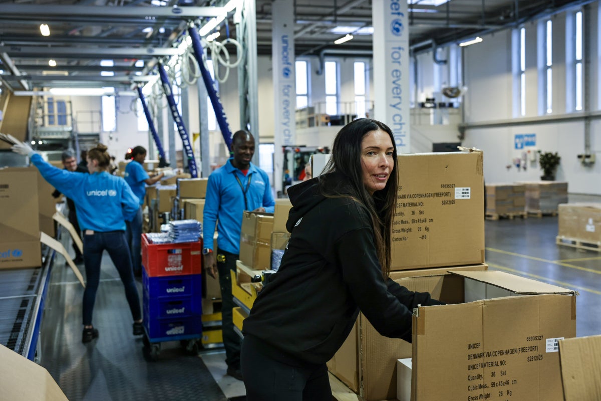 A woman standing in front of a conveyer belt in front of a box