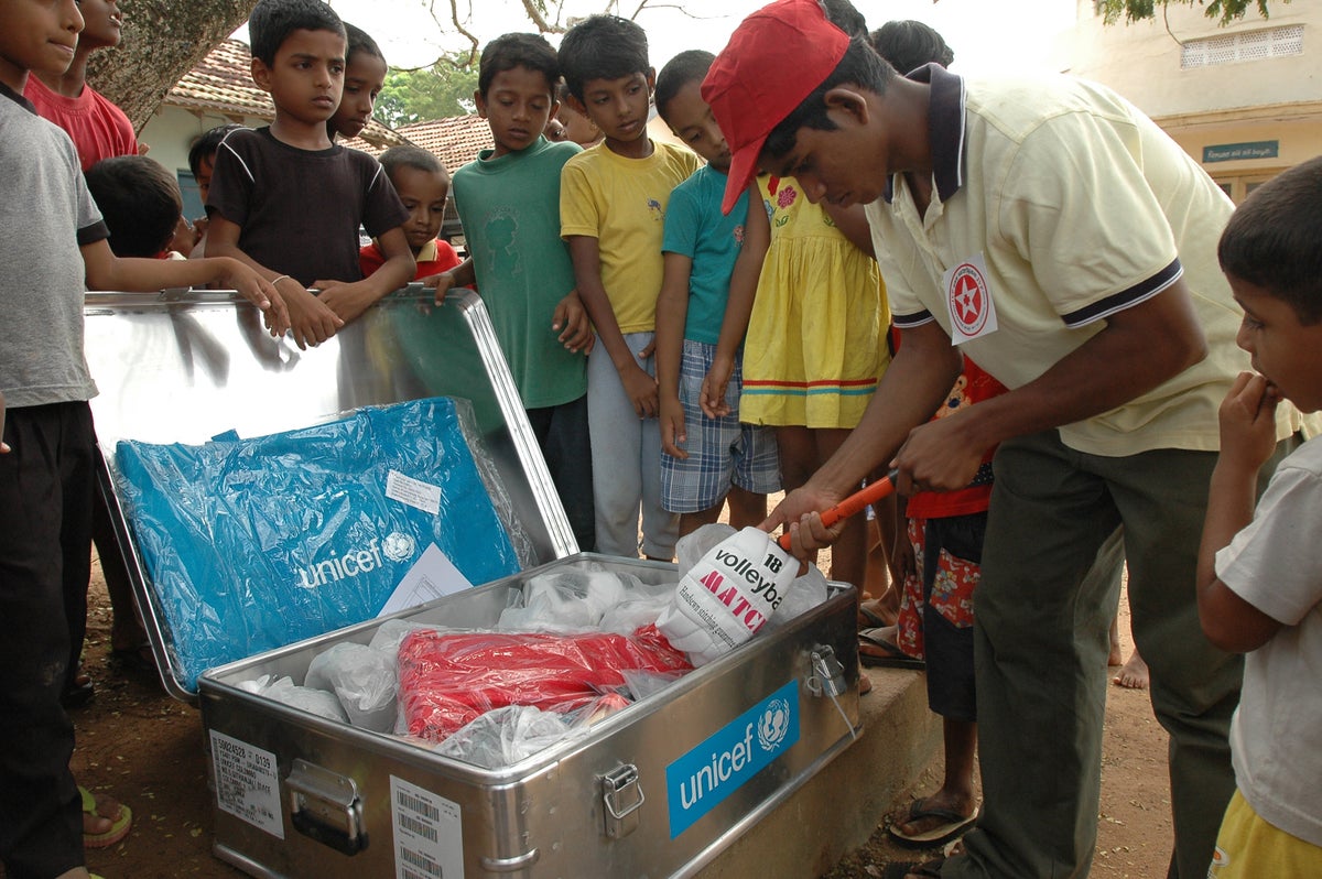 Children gather around as games from a UNICEF Recreation Kit are distributed at a relief camp for people displaced by the tsunami in Sri Lanka. 