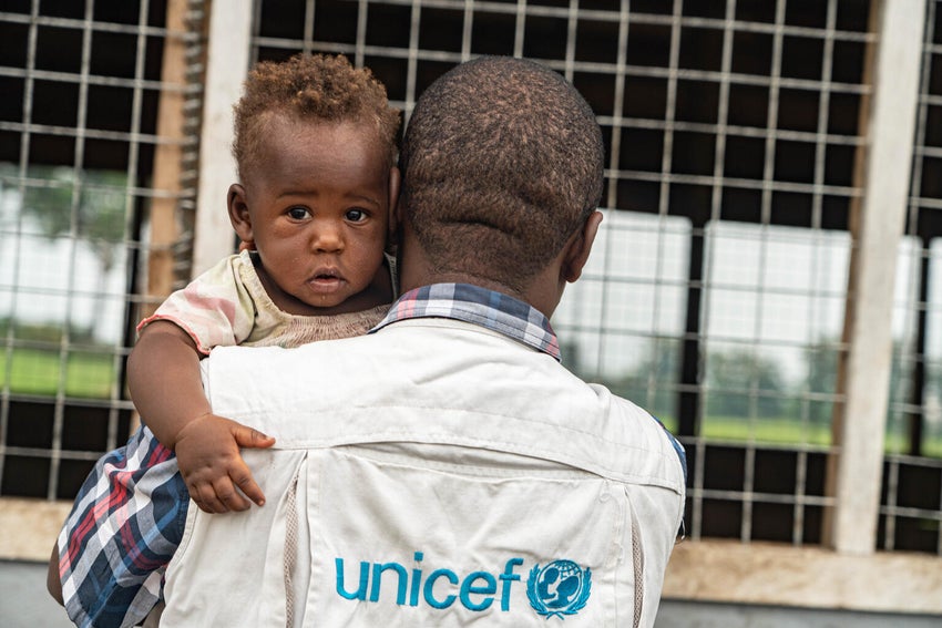 A UNICEF worker helps a child in the DRC.