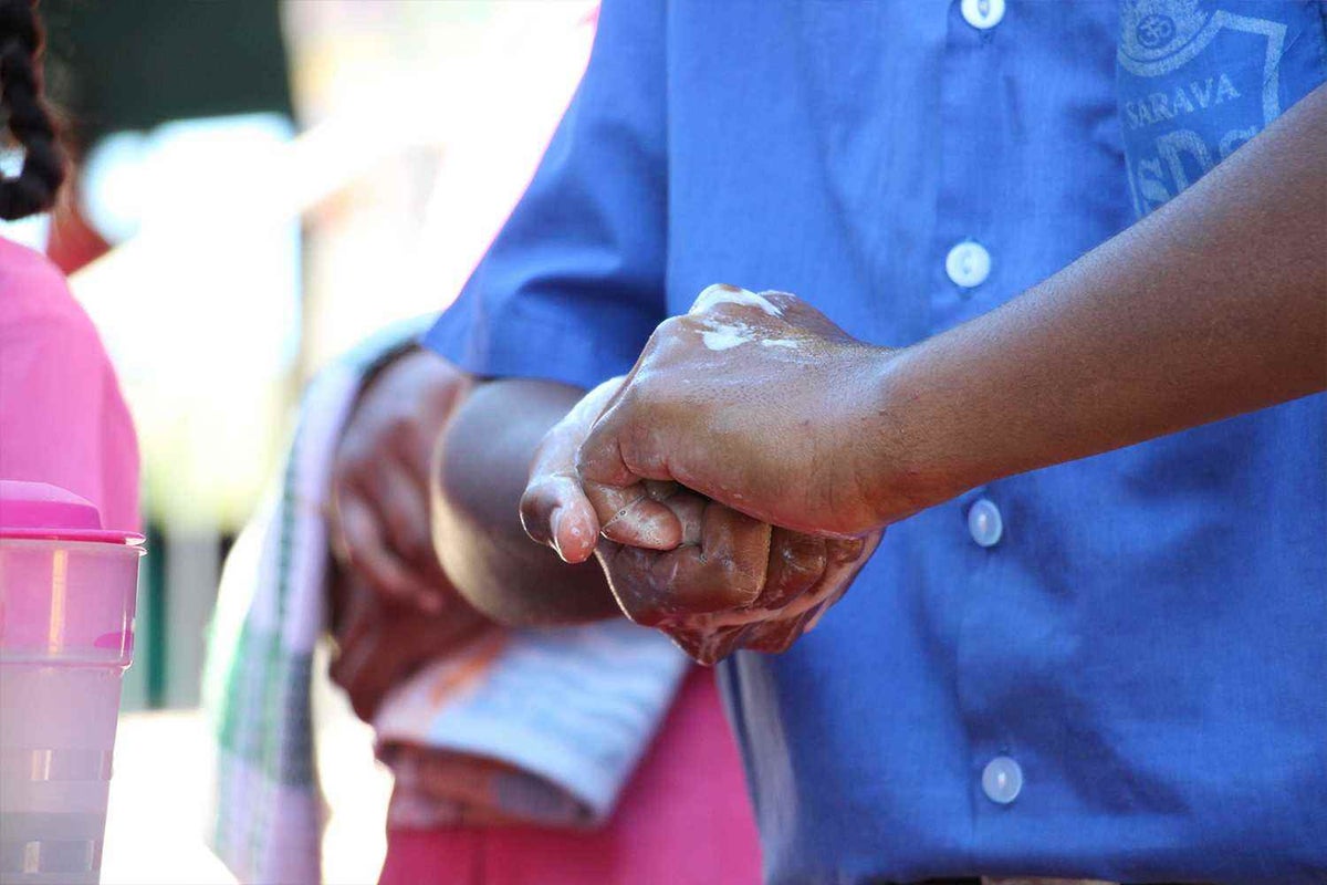 Child washes their hands at school