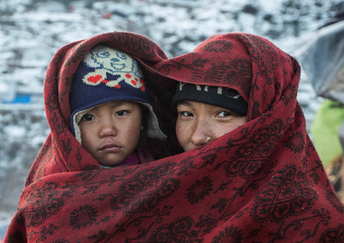 Maya Gurung covers her daughter Ritu with a blanket to protect her from cold weather in snowy Nepal in 2016. Maya’s family live near the epicentre of the 2015 Nepal earthquakes. 