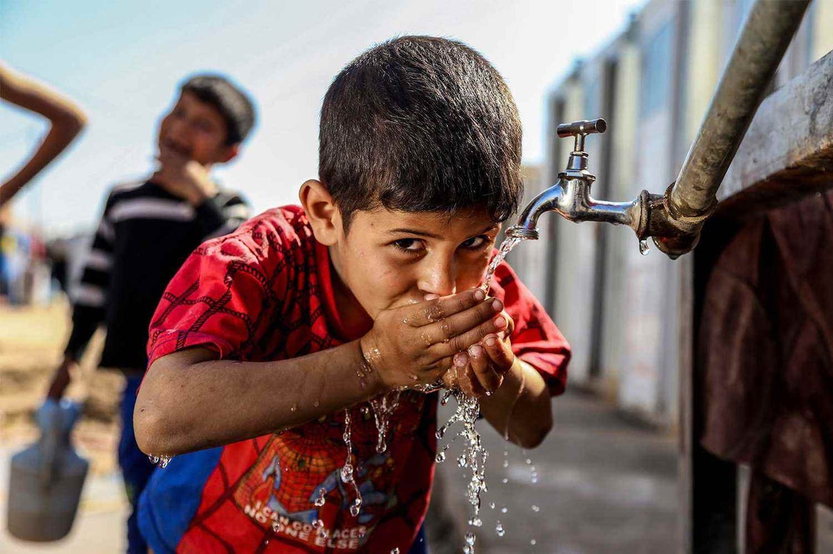 Water reaches a boy at Al-Takiya camp, Baghdad. 