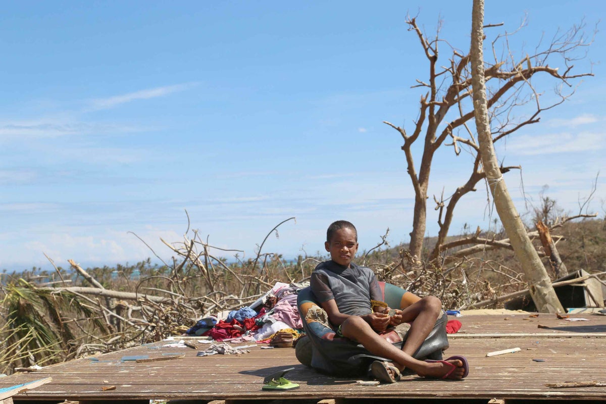 Gabriel is sitting in what used to be his house. During the storm, he was in the house with his mother, three sisters and brother when the roof and walls were blown away.