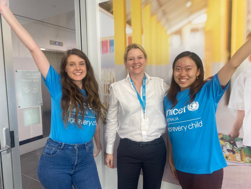 UNICEF workers holding their hands up