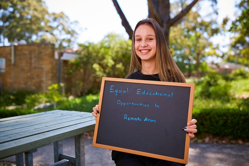 A young girl holding a sign that says that everyone has the right to an education.