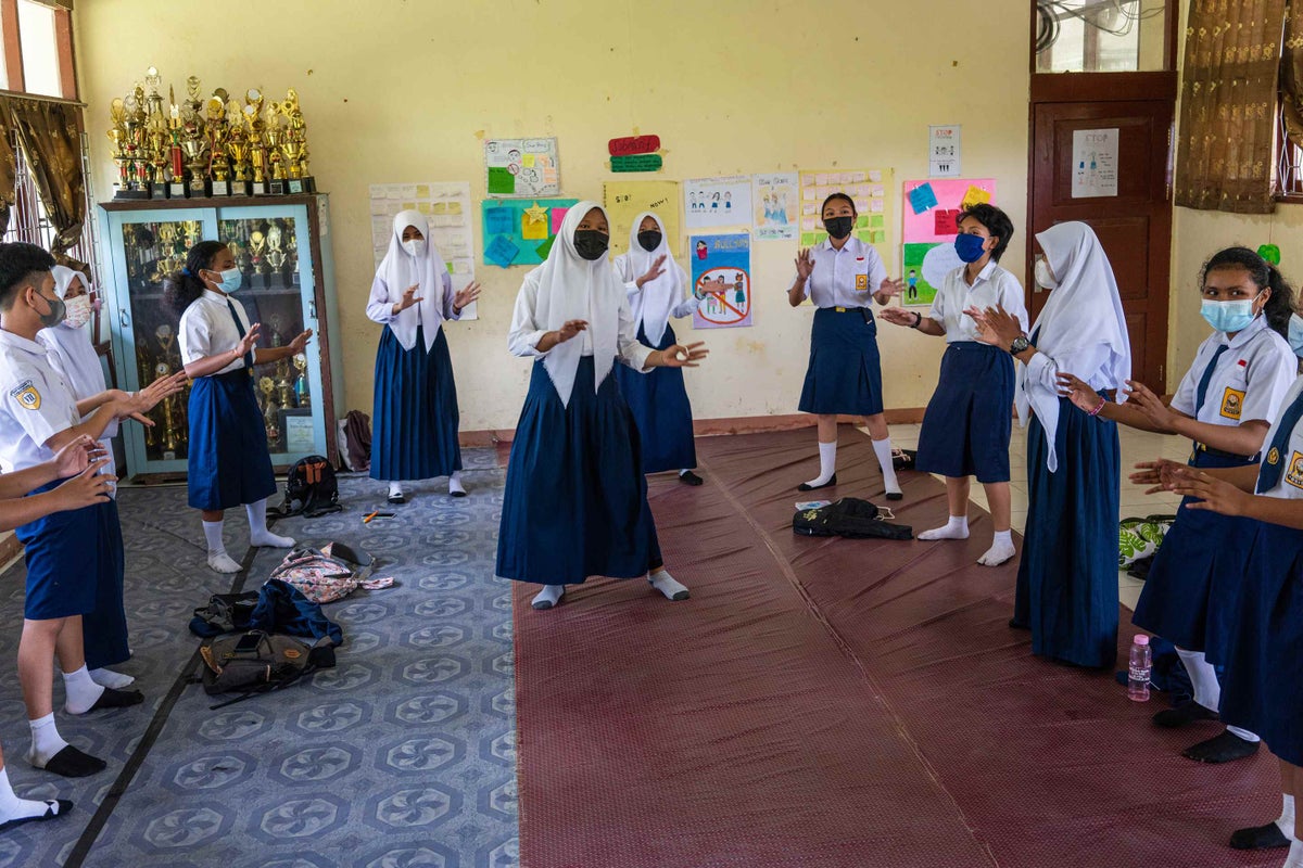 Young girl in middle in classroom, in a circle of other students