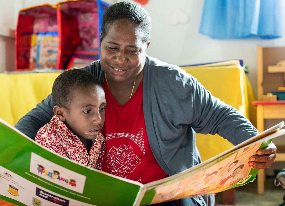 Felina reads to her daughter Yuli, five, at an Early Childhood Development Centre in West Papua Province, Indonesia.
