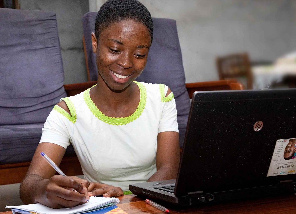 A girl, 15, taking notes in front of the laptop