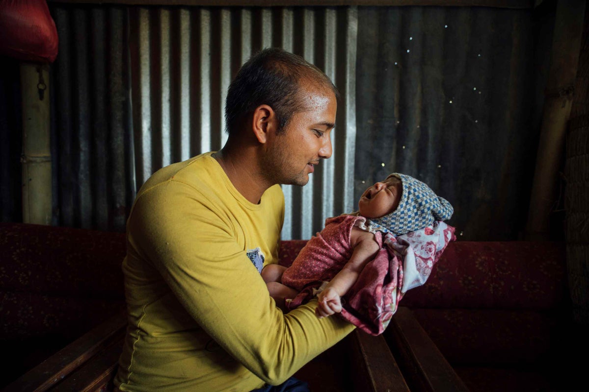 Nayaran smiles at his newborn, Nirman