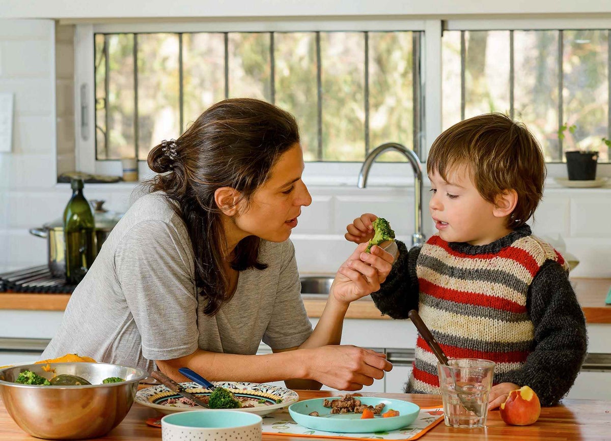 Joaquín, 2, is offered broccoli by his mother, Rosina, during lunch at their home