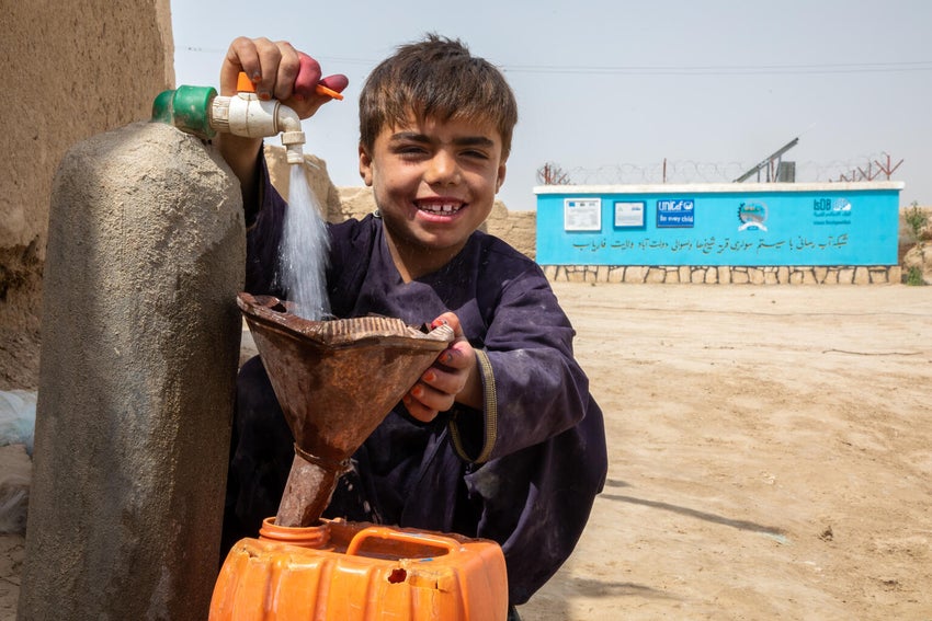 Nine-year-old Kanaan fills a water bottle at UNICEF-supported water tap in Afghanistan.